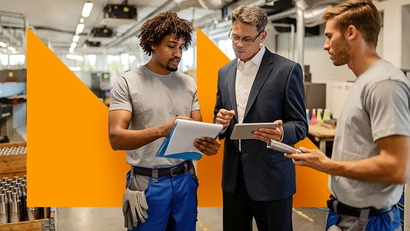 A team discussing a product, with orange geometric branding.