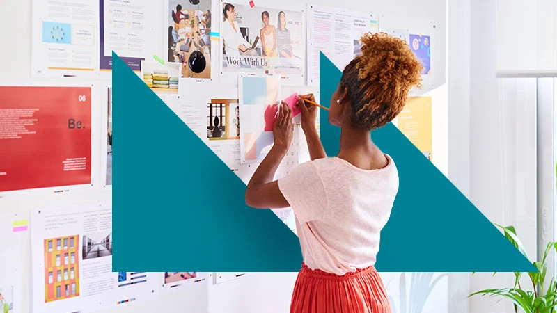 A designer arranging ideas on a wall, with teal geometric branding.