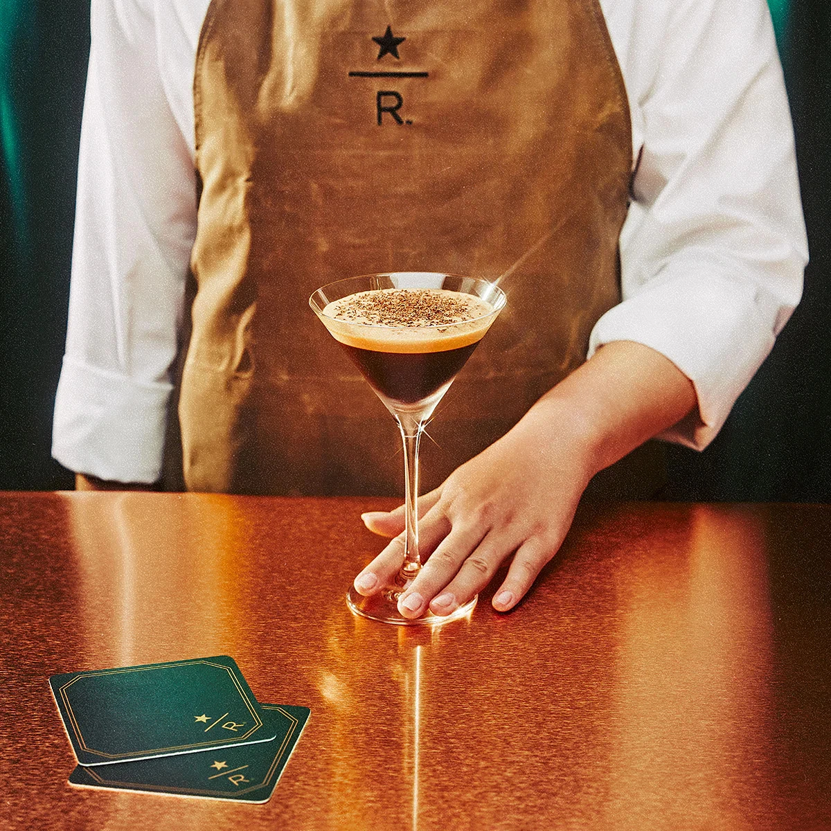 Photograph of a barista presenting a cocktail.